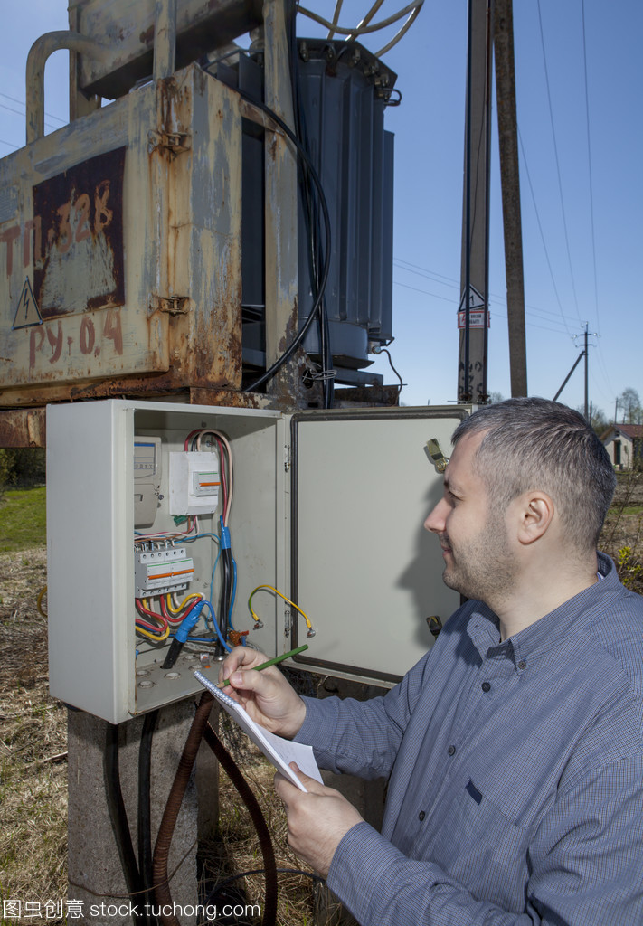 農(nóng)村變電站,農(nóng)夫檢查電力計數(shù)器檢查消費(fèi)